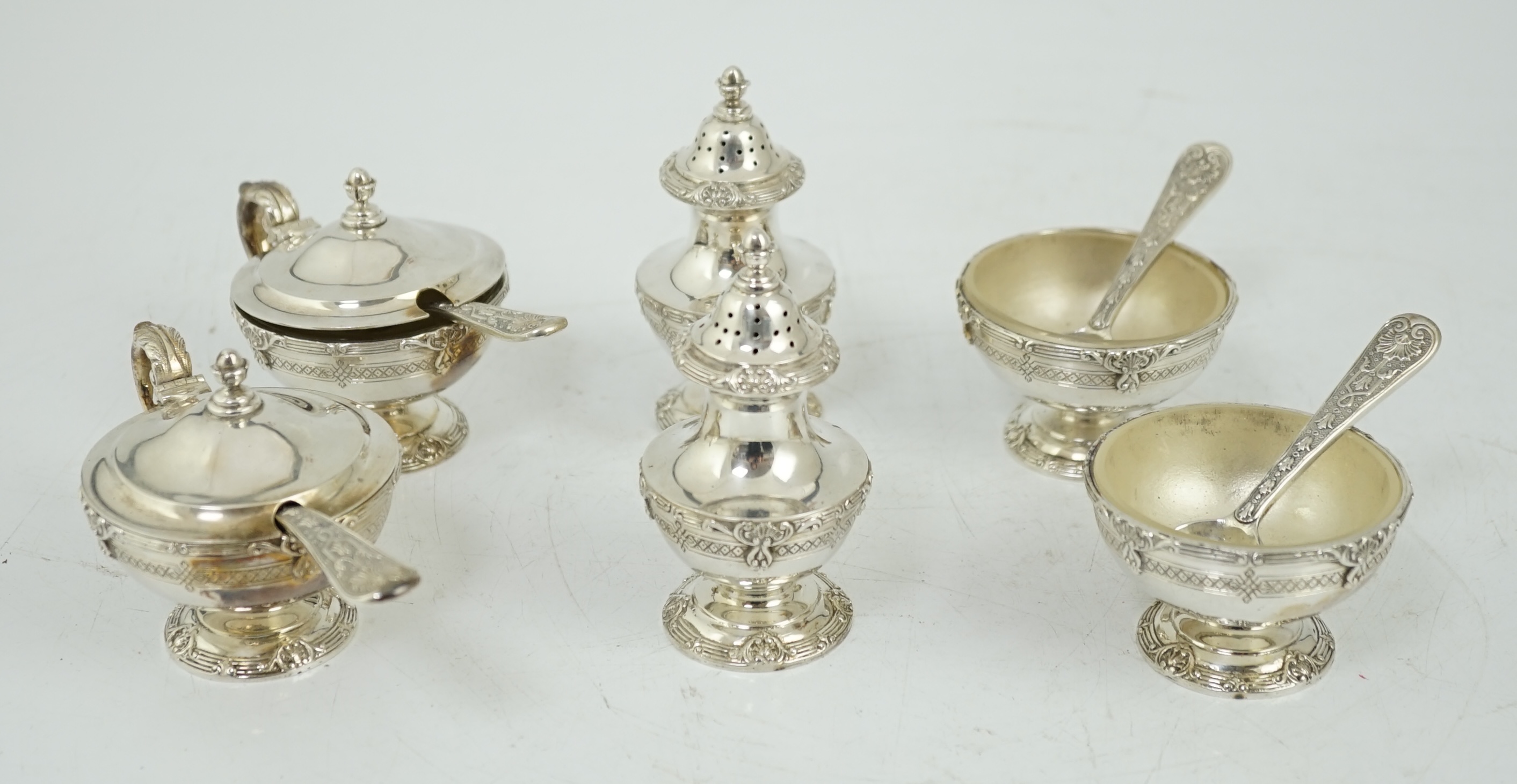 An Elizabeth II cased silver six piece pedestal condiment set, with four matching spoons, by Garrard & Co